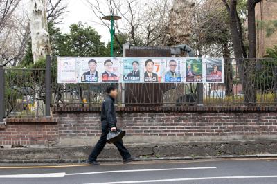 제22대 국회의원선거 종로구 출마 후보 선거 벽보 앞을 지나가고 있는 시민