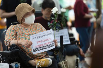 국화꽃과 손 피켓을 든 전국 장애인 단체 활동가