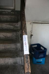 서소문아파트 9동 1층 계단 손잡이에 붙은 안내문